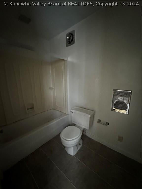 bathroom with tile patterned floors, shower / bathing tub combination, and toilet