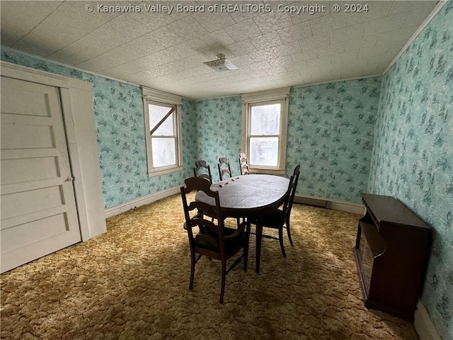 carpeted dining room with crown molding