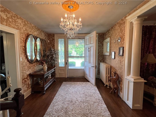 entryway featuring radiator heating unit, dark hardwood / wood-style flooring, decorative columns, and a notable chandelier