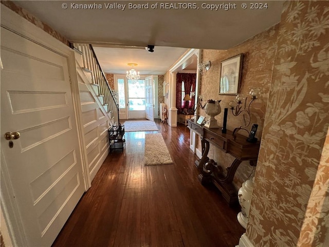 hallway with dark hardwood / wood-style floors and a chandelier