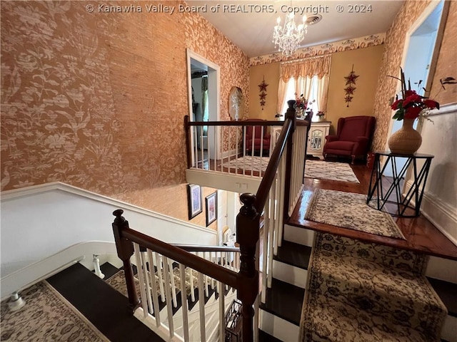 stairs with a notable chandelier