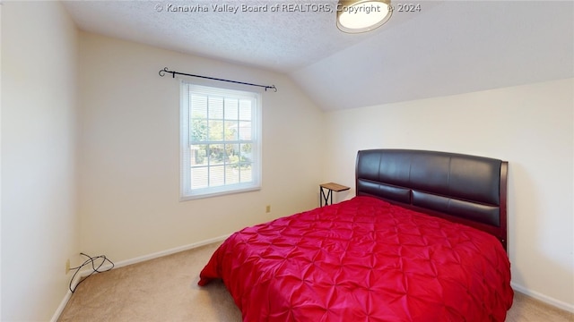 carpeted bedroom with a textured ceiling and vaulted ceiling