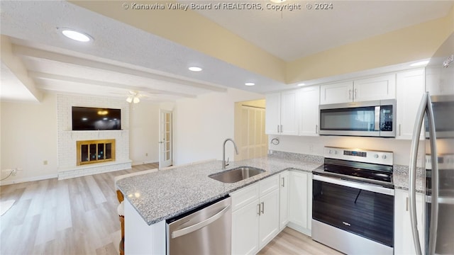 kitchen featuring kitchen peninsula, white cabinetry, light hardwood / wood-style flooring, and stainless steel appliances