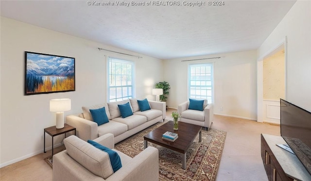 living room featuring a textured ceiling, light colored carpet, and a healthy amount of sunlight