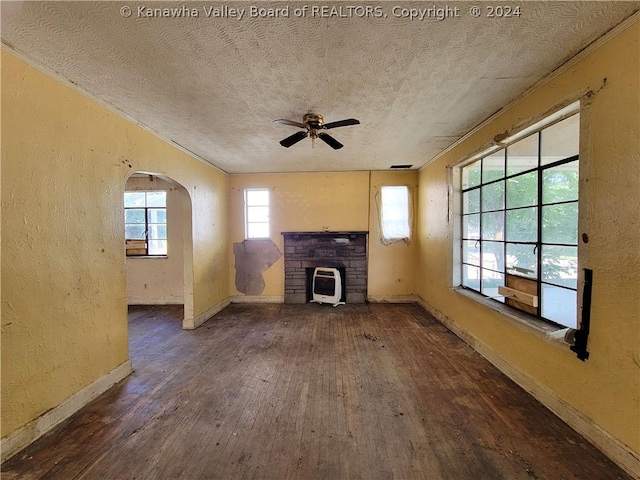 unfurnished living room with ceiling fan, dark wood-type flooring, and a textured ceiling