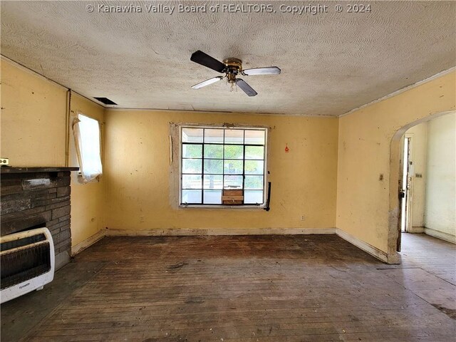 unfurnished living room featuring a textured ceiling, a fireplace, and ceiling fan