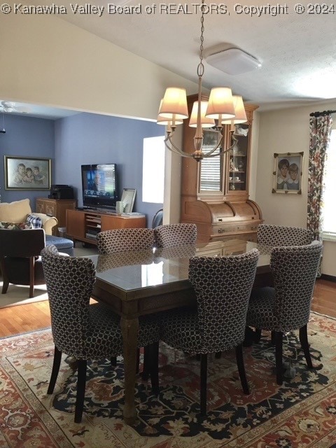 dining area with a notable chandelier, lofted ceiling, and hardwood / wood-style flooring