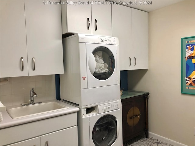 laundry room with sink, cabinets, light tile patterned floors, and stacked washer / drying machine