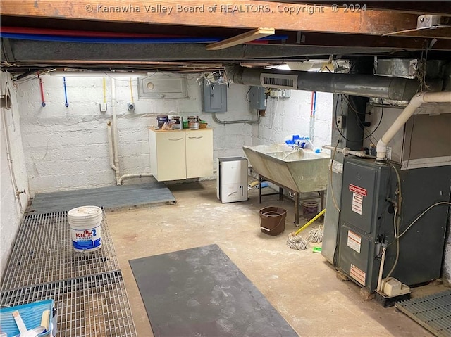 basement with sink, electric panel, and heating unit