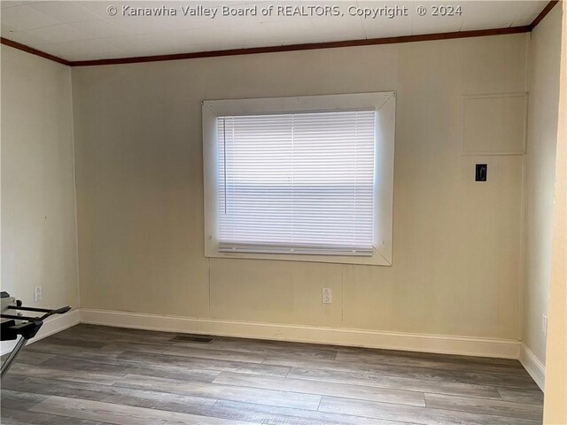 spare room with crown molding and hardwood / wood-style floors