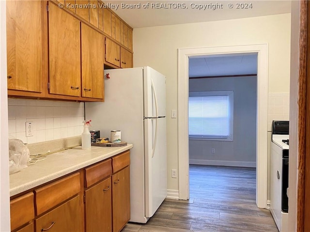 kitchen featuring decorative backsplash, white appliances, and dark hardwood / wood-style floors