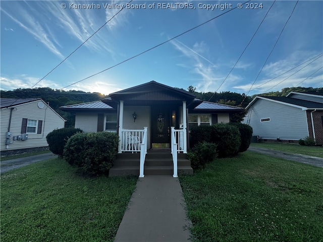 bungalow-style house featuring a porch and a front lawn