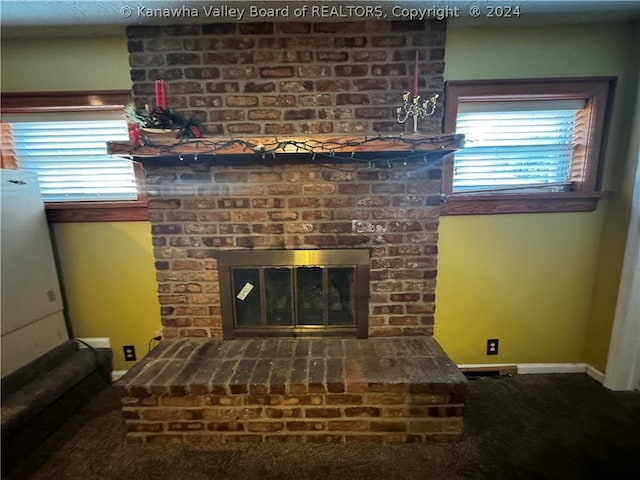 room details featuring a brick fireplace and carpet floors