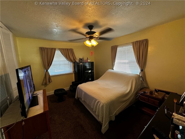 carpeted bedroom with ceiling fan, a closet, and a textured ceiling