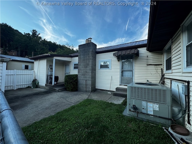 exterior space with central AC unit and a yard