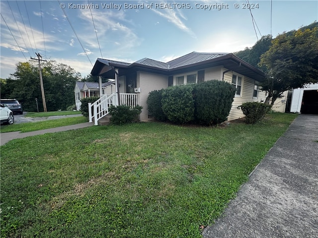 view of home's exterior with a lawn and covered porch