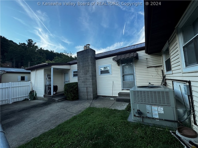 exterior space with cooling unit and a lawn