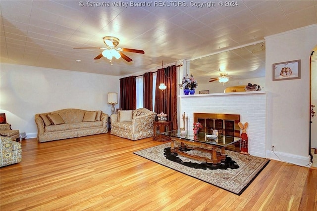 living room featuring hardwood / wood-style flooring, a fireplace, and ceiling fan