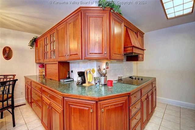 kitchen featuring light tile patterned flooring, premium range hood, backsplash, and black electric cooktop