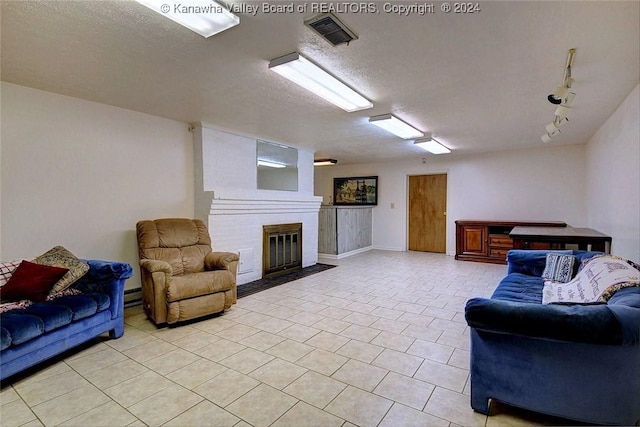 tiled living room featuring baseboard heating, a fireplace, and a textured ceiling