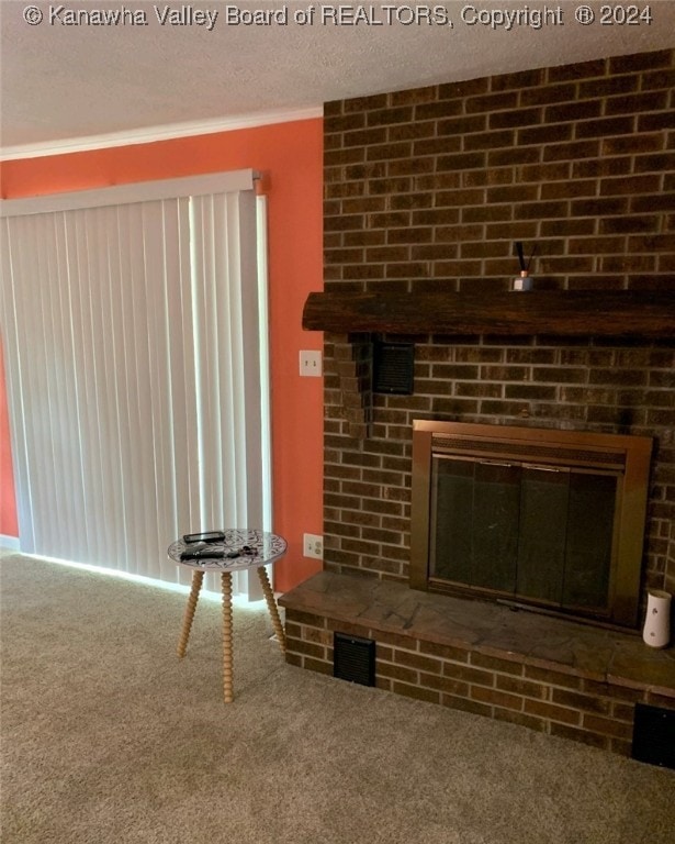 carpeted living room featuring a fireplace, brick wall, and a textured ceiling