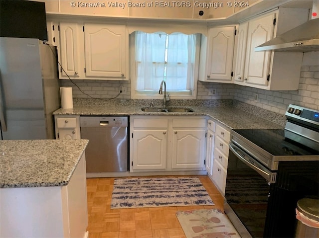 kitchen featuring white cabinets, stainless steel appliances, wall chimney exhaust hood, and sink