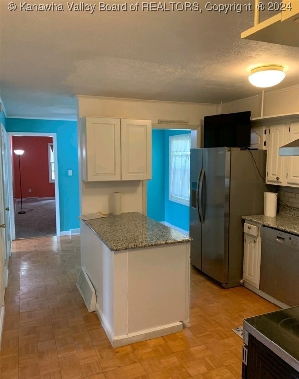 kitchen with white cabinetry, stainless steel appliances, light parquet flooring, decorative backsplash, and stone countertops