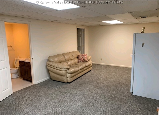 living area featuring a drop ceiling and light colored carpet