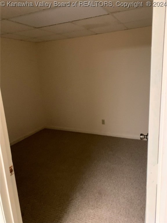 carpeted empty room featuring a paneled ceiling