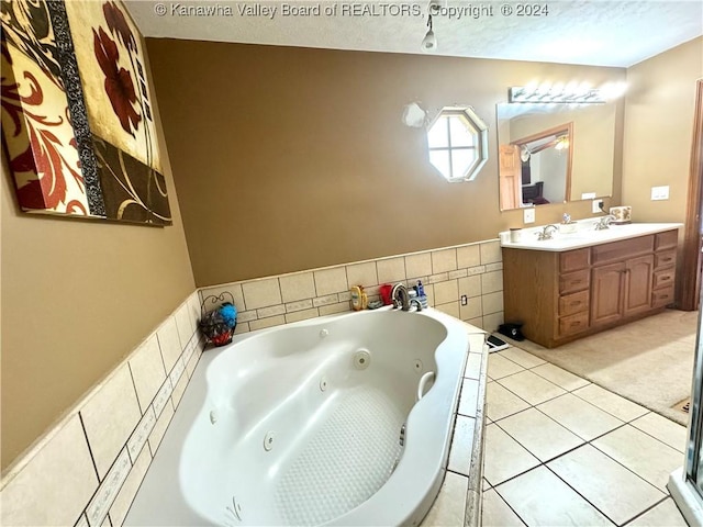 bathroom featuring a washtub, vanity, tile patterned flooring, and a textured ceiling