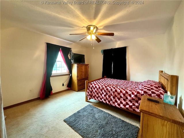 carpeted bedroom featuring ceiling fan and a textured ceiling