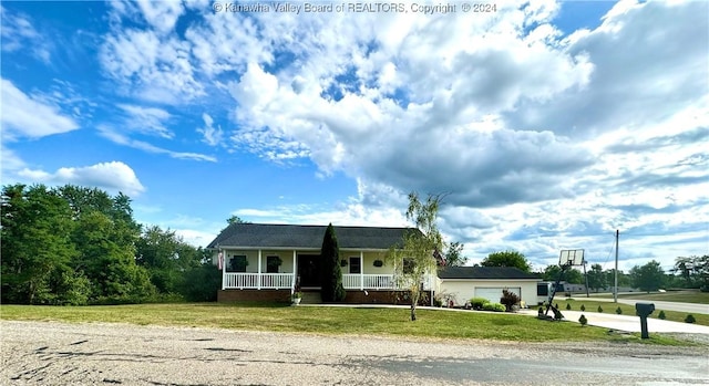 view of front facade featuring a garage, a front lawn, and covered porch