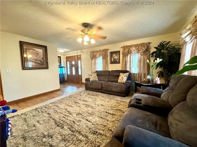 living room with hardwood / wood-style floors, a textured ceiling, and ceiling fan