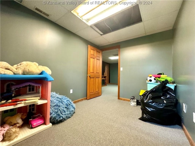 recreation room featuring a paneled ceiling and carpet