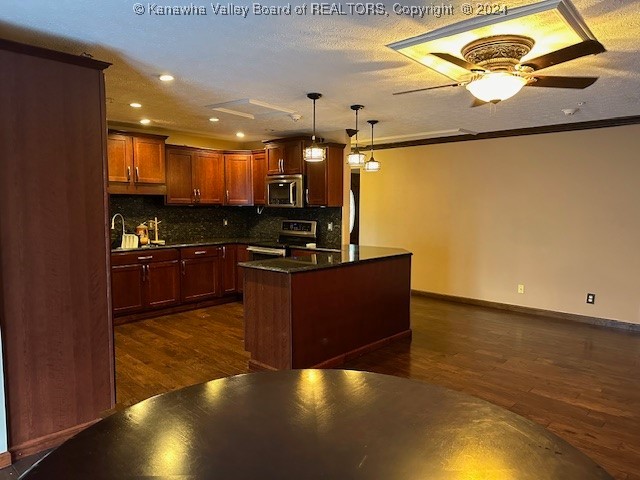 kitchen with ceiling fan, stainless steel appliances, ornamental molding, dark hardwood / wood-style floors, and backsplash