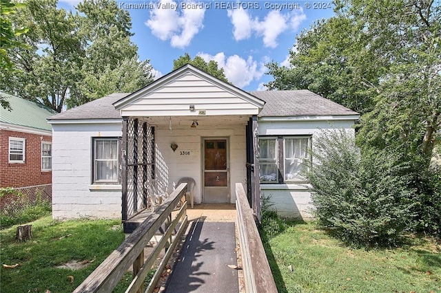 bungalow-style house with roof with shingles and fence