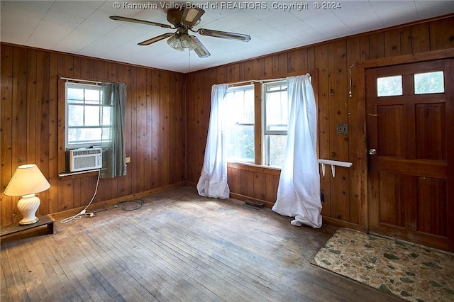 foyer entrance with ceiling fan, cooling unit, hardwood / wood-style flooring, and baseboards