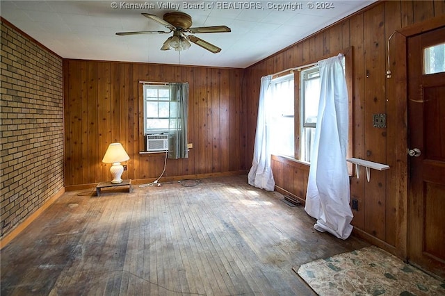 interior space featuring brick wall, wood-type flooring, and a wealth of natural light