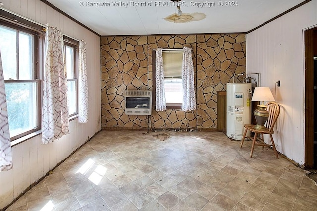 unfurnished room with heating unit, plenty of natural light, water heater, and crown molding