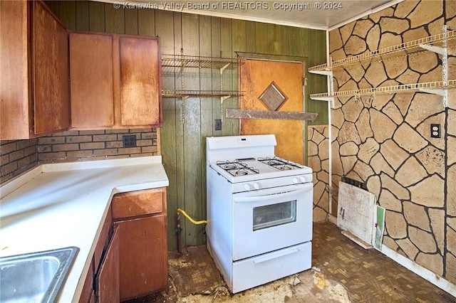 kitchen featuring brown cabinets, white gas range oven, light countertops, and a sink