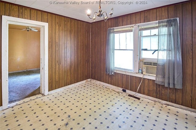 empty room featuring cooling unit, a wealth of natural light, a chandelier, and light carpet