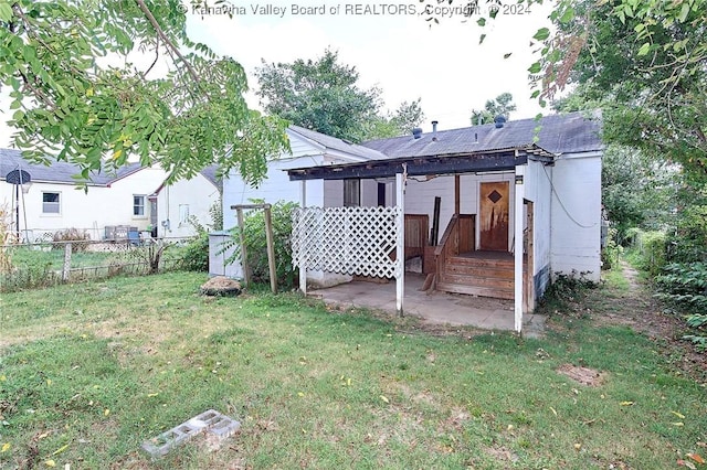 rear view of property featuring a yard and fence