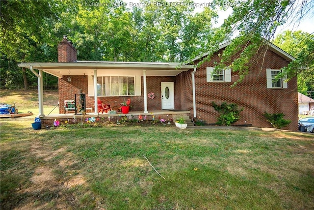 view of front facade featuring a front yard, covered porch, brick siding, and a chimney