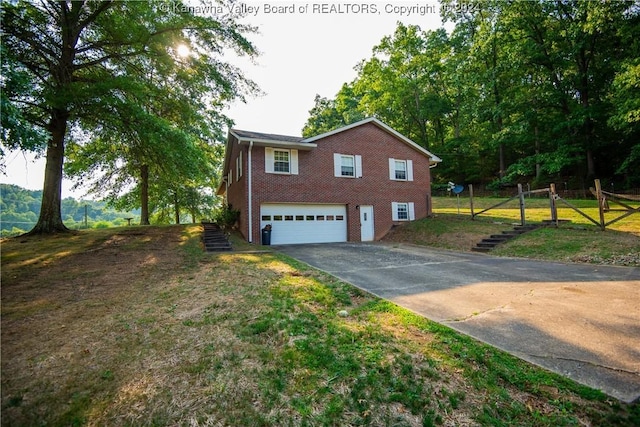 view of home's exterior featuring driveway, an attached garage, stairs, fence, and brick siding