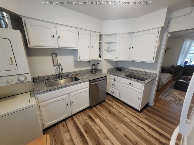 kitchen featuring stacked washer and dryer, dishwasher, light hardwood / wood-style flooring, and sink