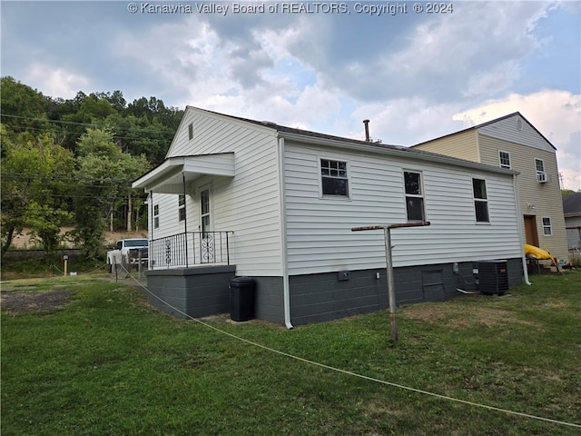 view of side of property featuring cooling unit and a lawn