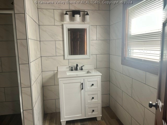 bathroom with tile walls, hardwood / wood-style flooring, and vanity