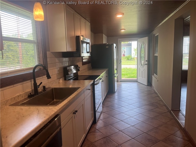 kitchen with appliances with stainless steel finishes, backsplash, sink, and white cabinets