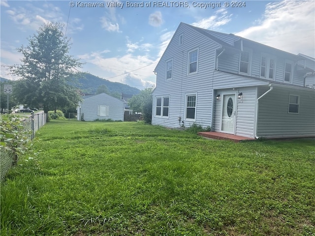 rear view of property featuring a lawn