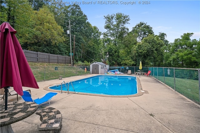 view of pool featuring a storage unit and a patio area